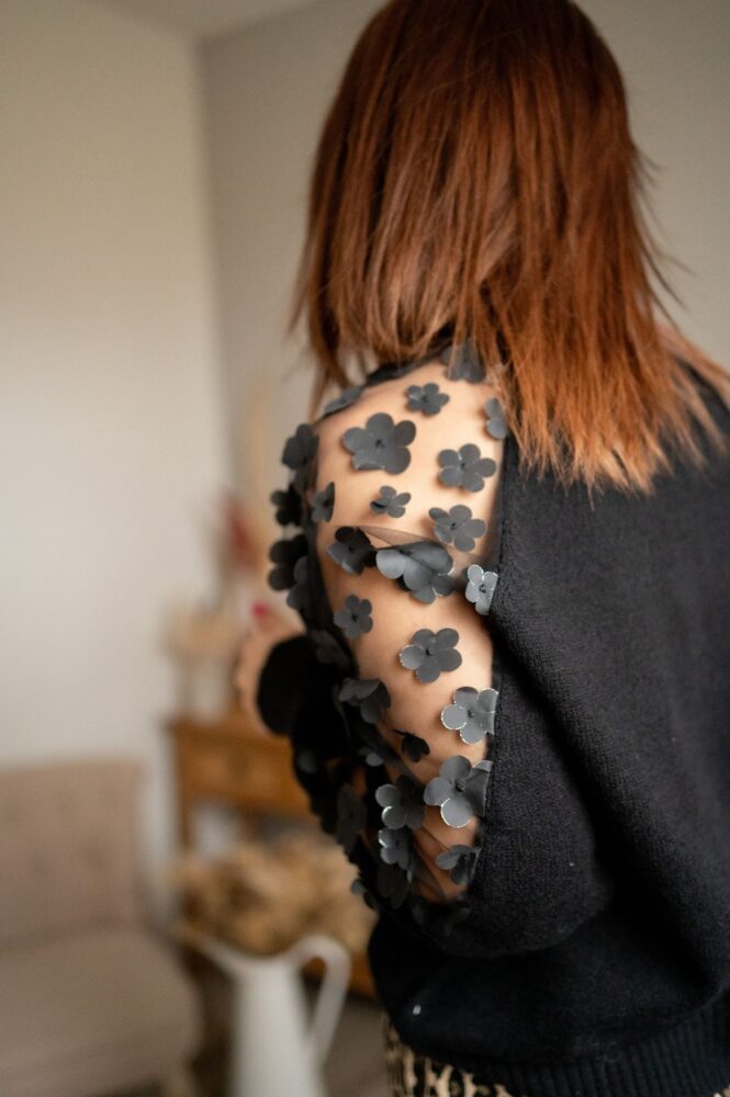 pull en laine noir, fleur noir brodées sur les manches